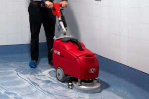Cleaning staff demonstrating how to use a scrubber dryer sustainably
