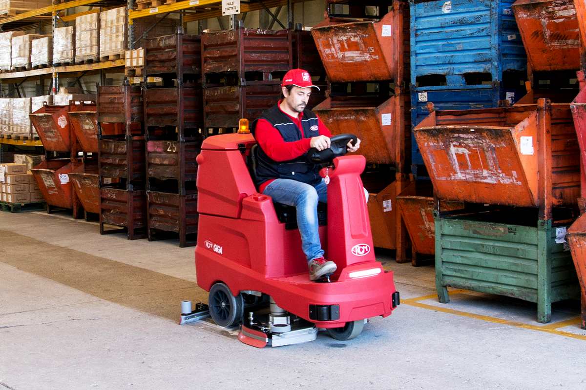 Ride-on scrubber dryer cleaning an industrial floor to reduce downtime